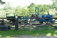 A blue tractor beyond a farm gate